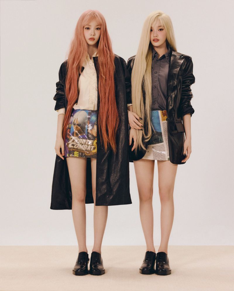 Two female models with long hair wearing black jackets and printed miniskirts against a plain light background for ODDA Magazine