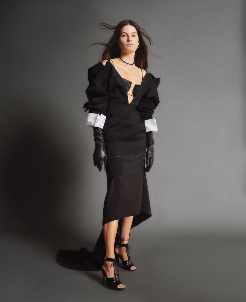 Model Isabeli Fontana wearing a black dress and leather gloves against a grey background for ODDA Magazine