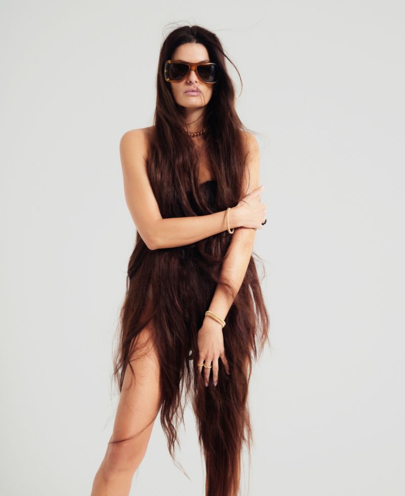 Model Isabeli Fontana wearing tortoiseshell sunglasses and gold bracelets against a plain white background for ODDA Magazine.
