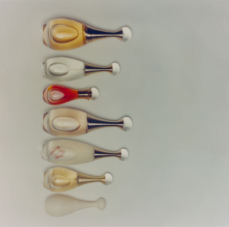 Seven perfume bottles arranged vertically on a pale background from The Majestic Aphrodite project for ODDA Magazine.