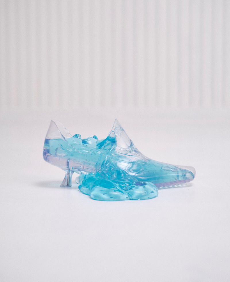 Transparent blue liquid shoe sculpture on white surface for ODDA Magazine