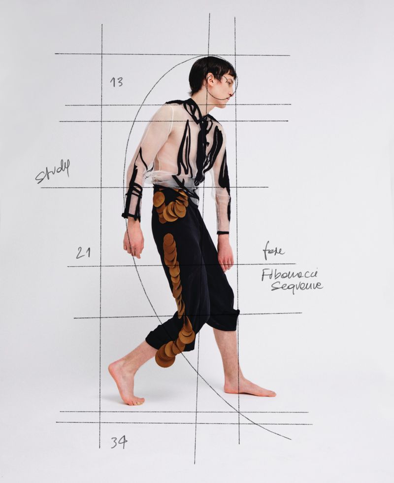 Model walking against a white background with overlaid Fibonacci sequence sketches and grid lines for ODDA Magazine.