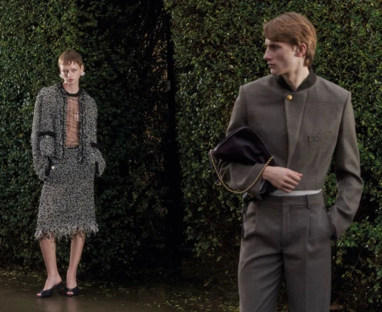 Two models posing outdoors before a dense green hedge for an editorial project titled The Debutants by ODDA Magazine.