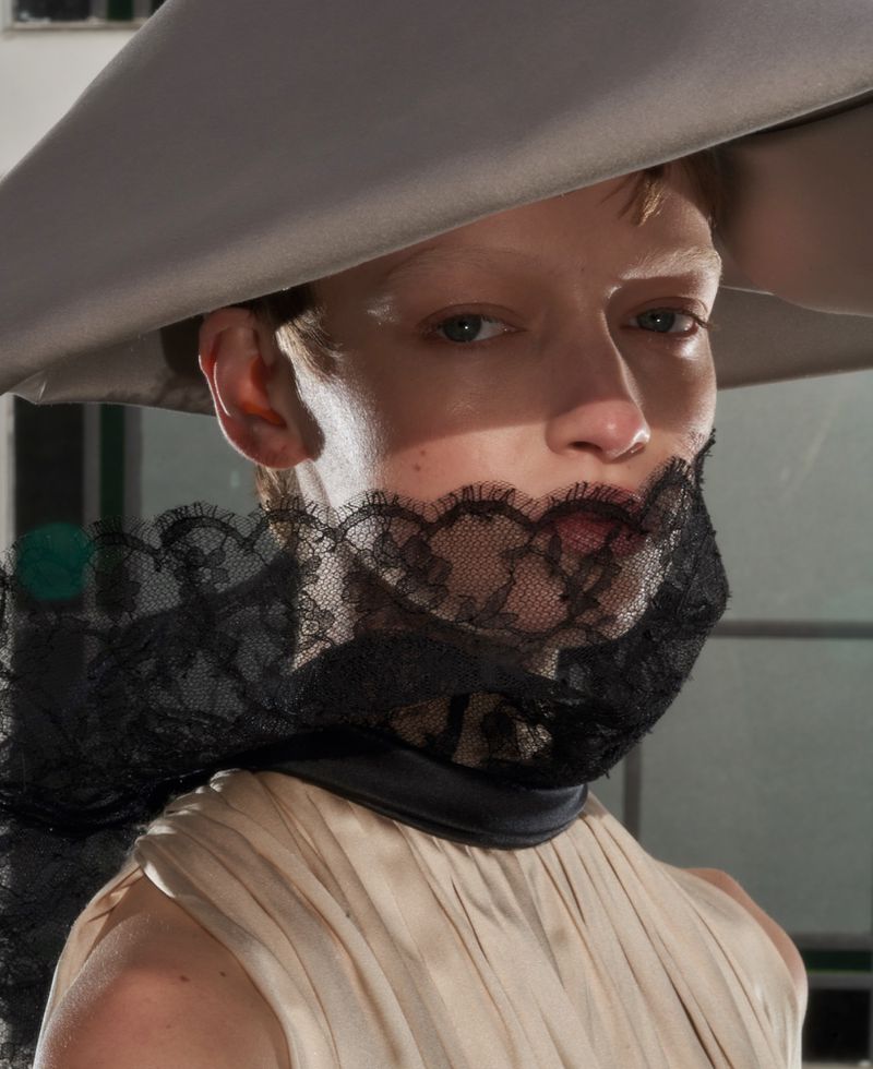 Close-up portrait of a model wearing a wide-brimmed grey hat and black lace veil for ODDA Magazine