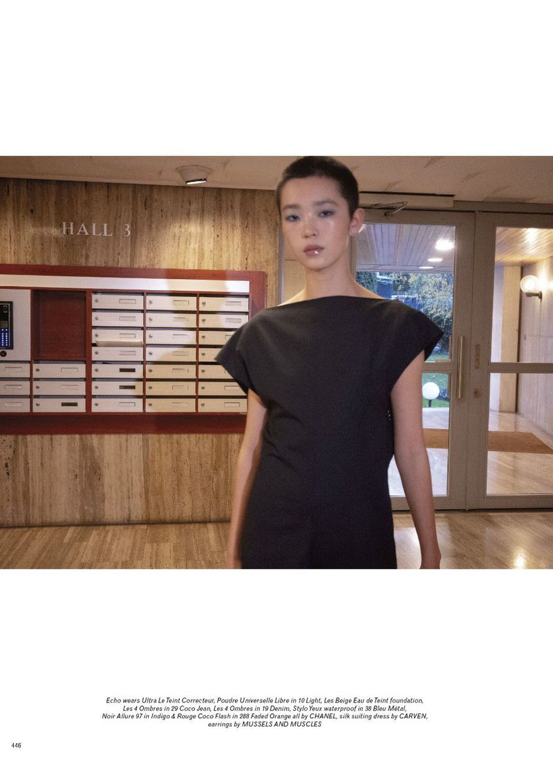 Model Echo Zhao in a dark top standing inside an apartment lobby with mailboxes for Pop Magazine