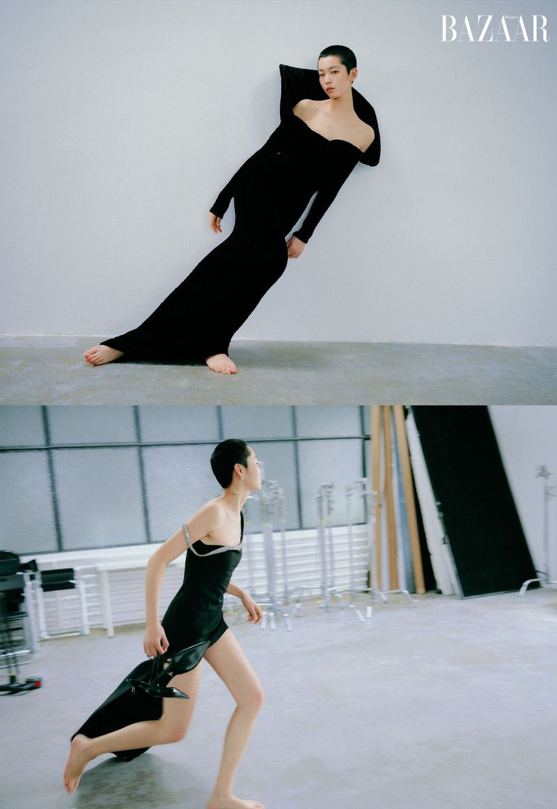 Model with short hair wearing a black off-shoulder gown against a white wall in Harper's Bazaar China fashion editorial