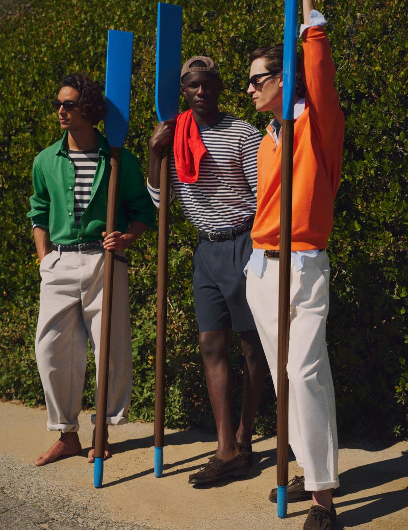 Three male models holding blue oars outdoors in front of a green hedge for Zara, photographed by Scott Trindle.