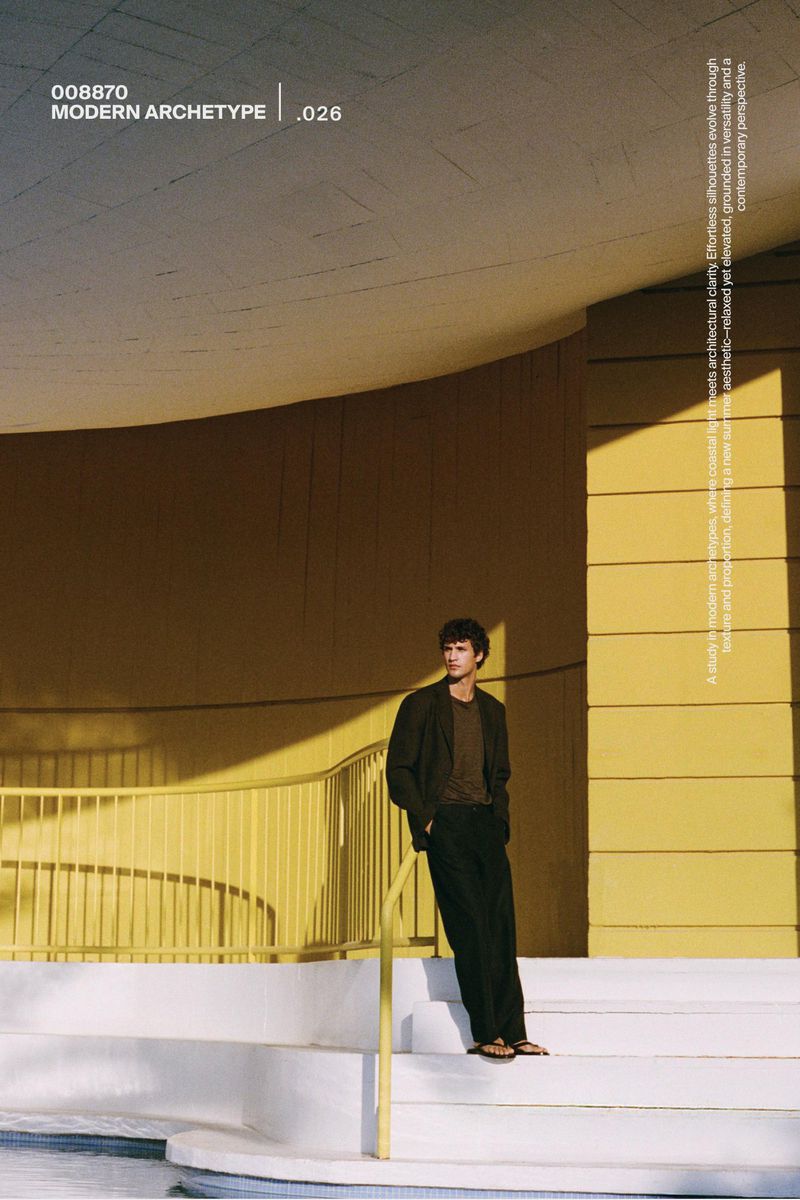 Model standing on white stairs against a modern yellow building exterior for Massimo Dutti Modern Archetype