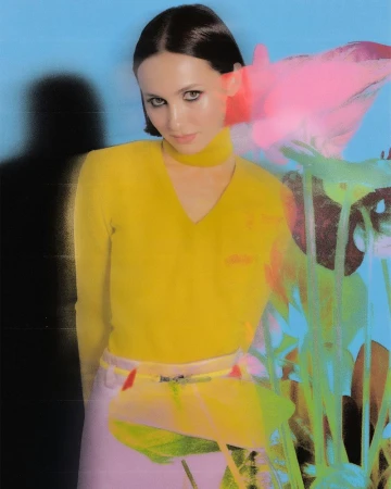 Maude Apatow wearing a yellow top against a blue background with pink and green floral overlay effects for Who What Wear.
