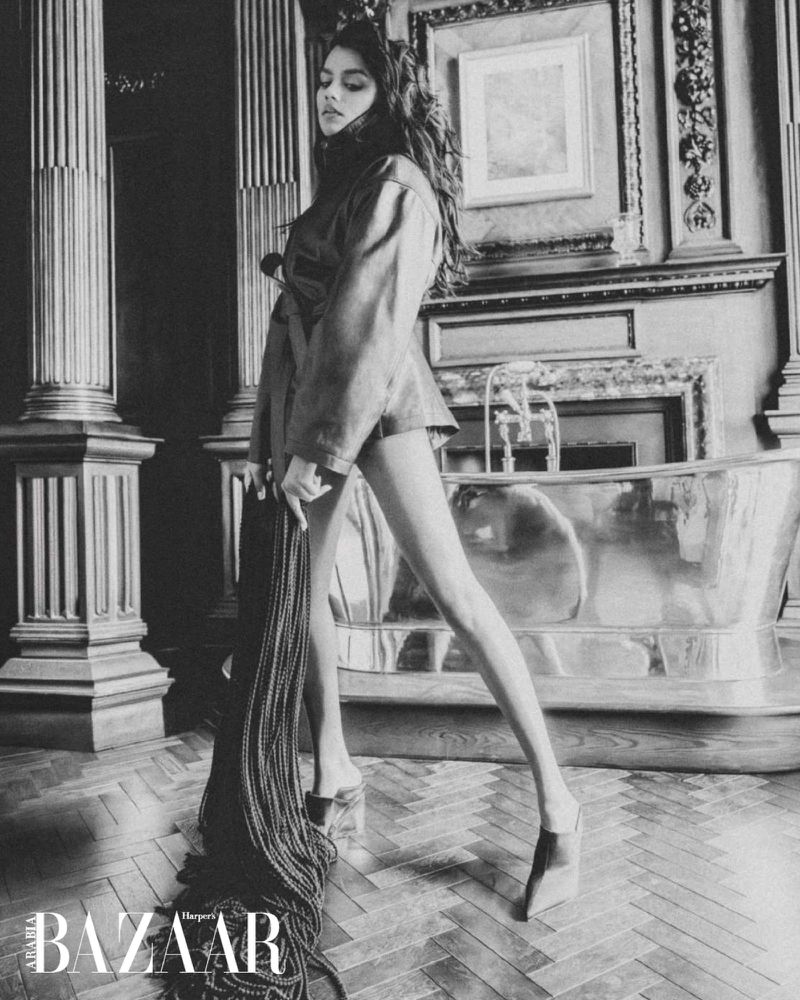 Simone Ashley in Harper's Bazaar Arabia editorial wearing a coat and mules inside a luxury bathroom