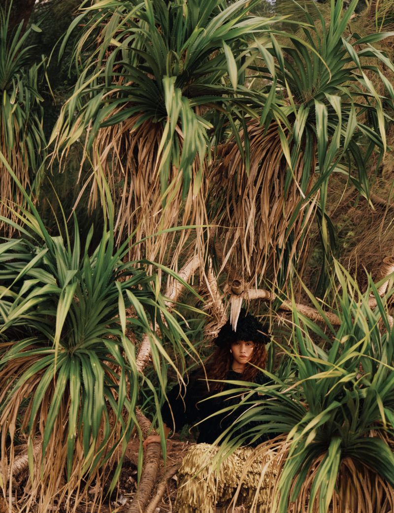 Model standing among lush tropical palm foliage and wild vegetation for Glass Magazine China project ISLAND