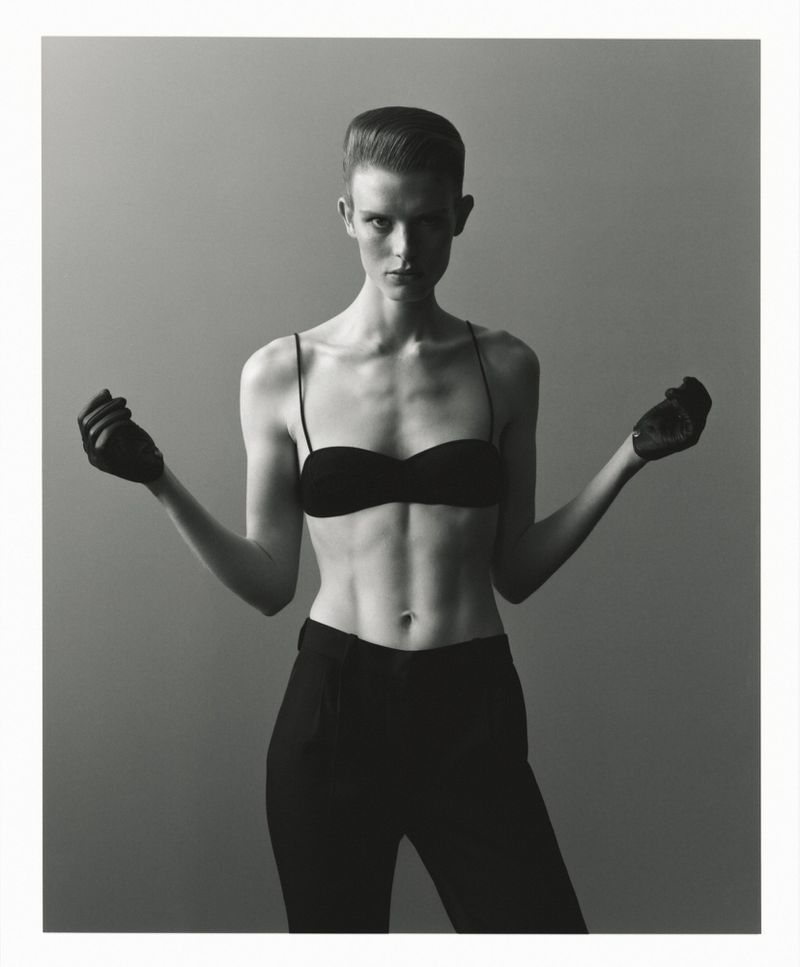 Model wearing black bandeau and trousers against a grey backdrop for SSAW Magazine