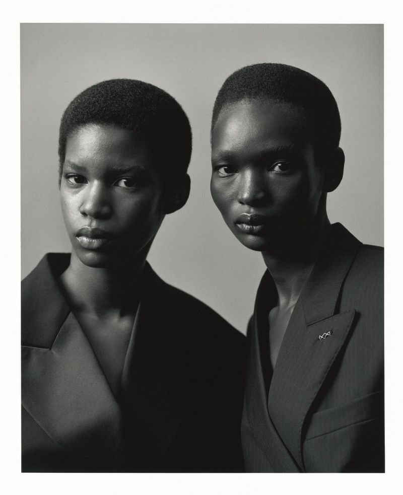 Two Black models with short hair wearing dark blazers against a plain studio background for SSAW Magazine
