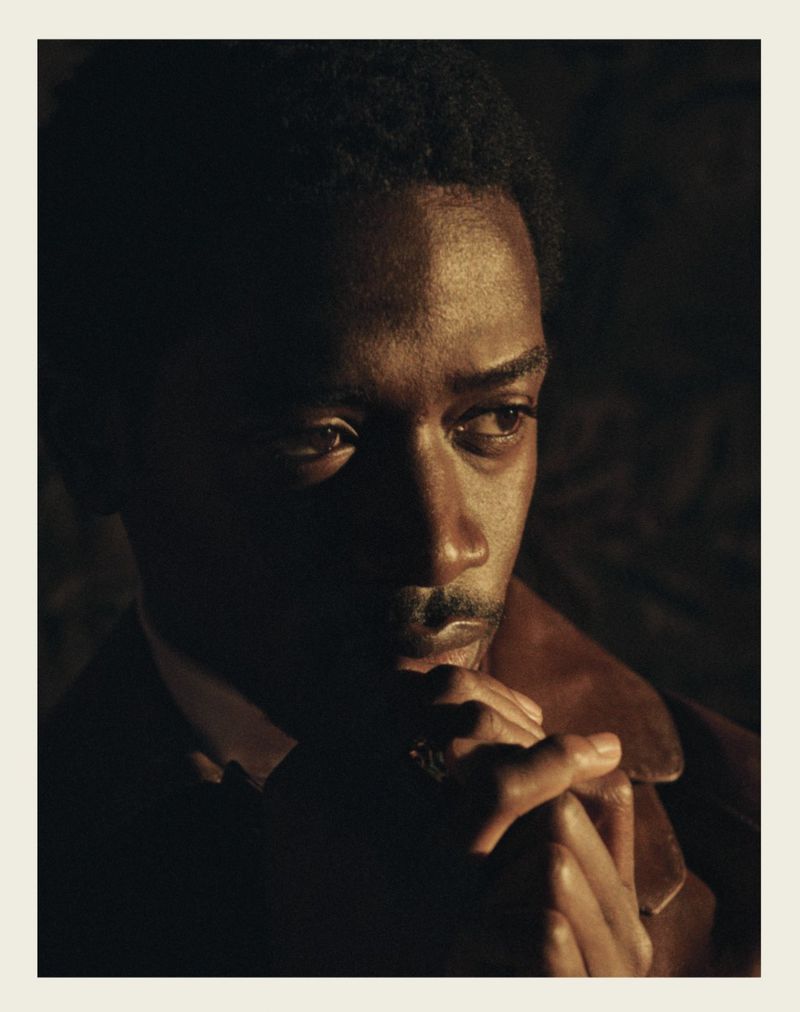 Portrait of Damson Idris with hands clasped in low-key dramatic lighting for ICON America