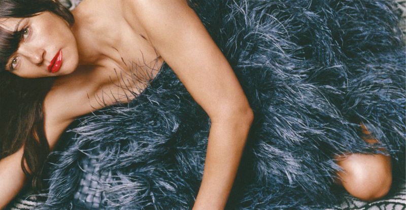 Rashida Jones wearing a textured dark feather dress posing in a horizontal fashion editorial photograph for Marfa.