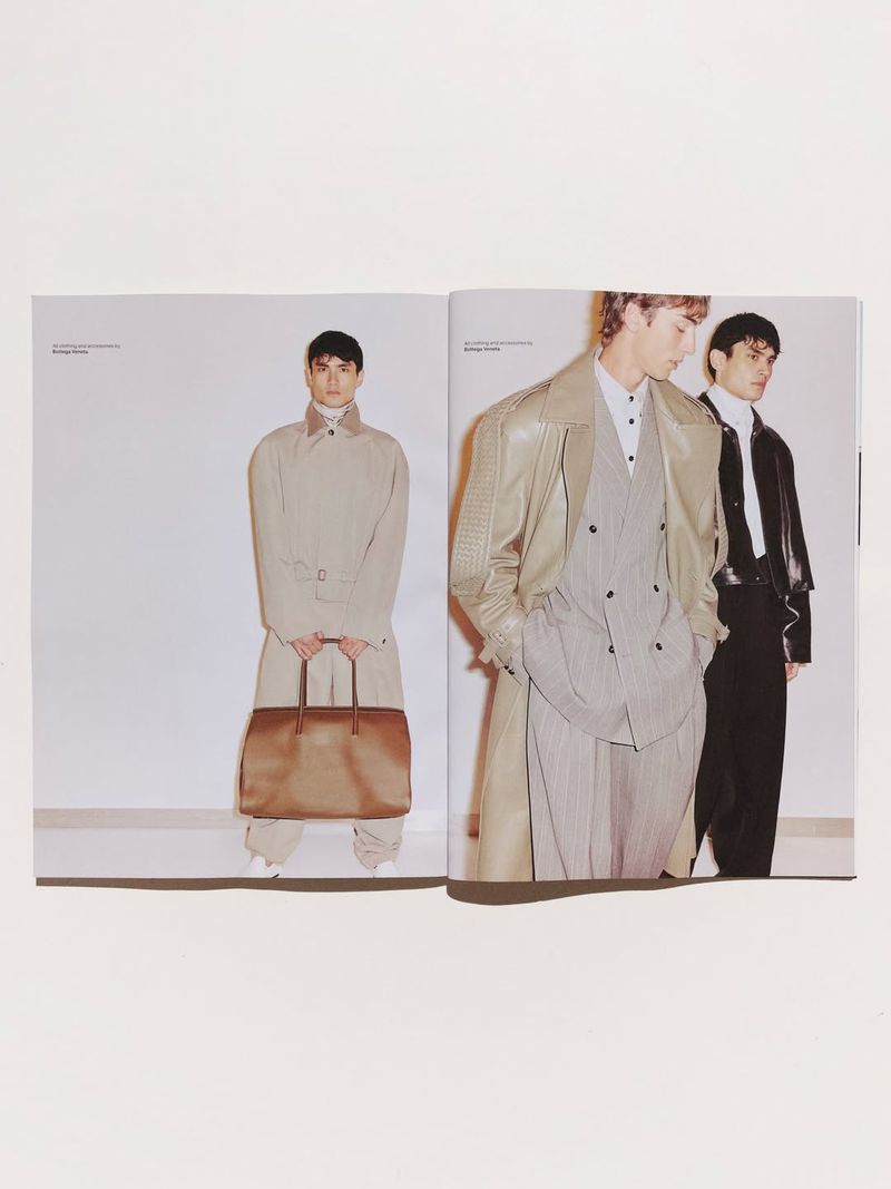 Spread from Esquire Australia magazine showing three male models wearing designer menswear and carrying large leather bags.