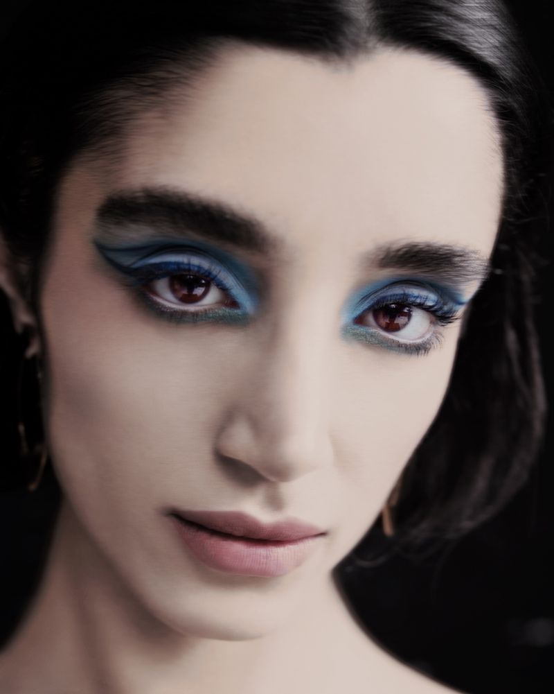 Close-up portrait of a woman with dramatic blue eye makeup and dark winged eyeliner for Numero Netherlands by Stephanie Pistel