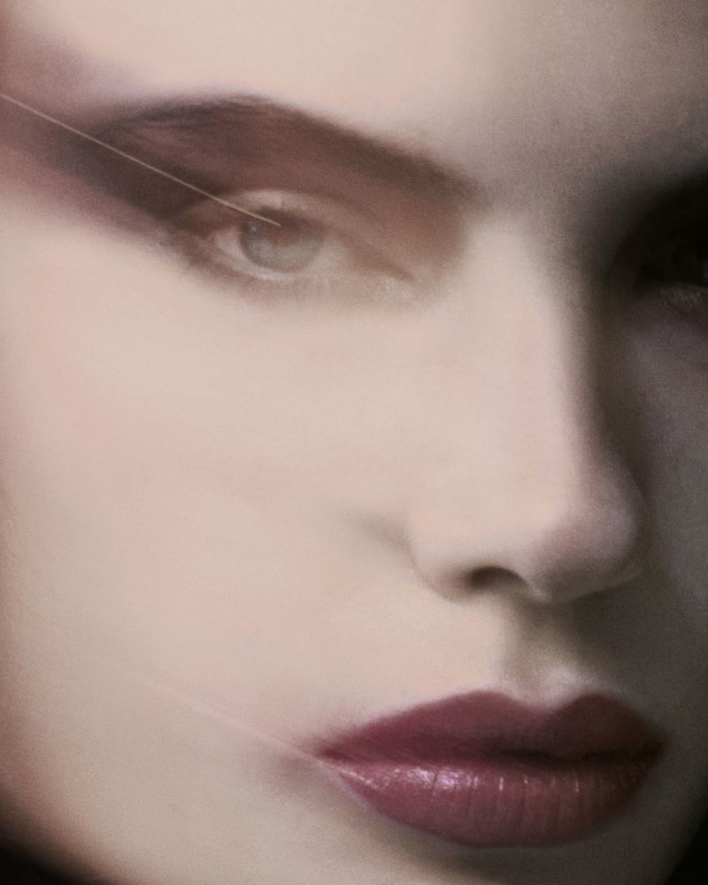 Close-up portrait of a woman with dramatic eye makeup and dark berry lips for Numero Netherlands editorial photography.