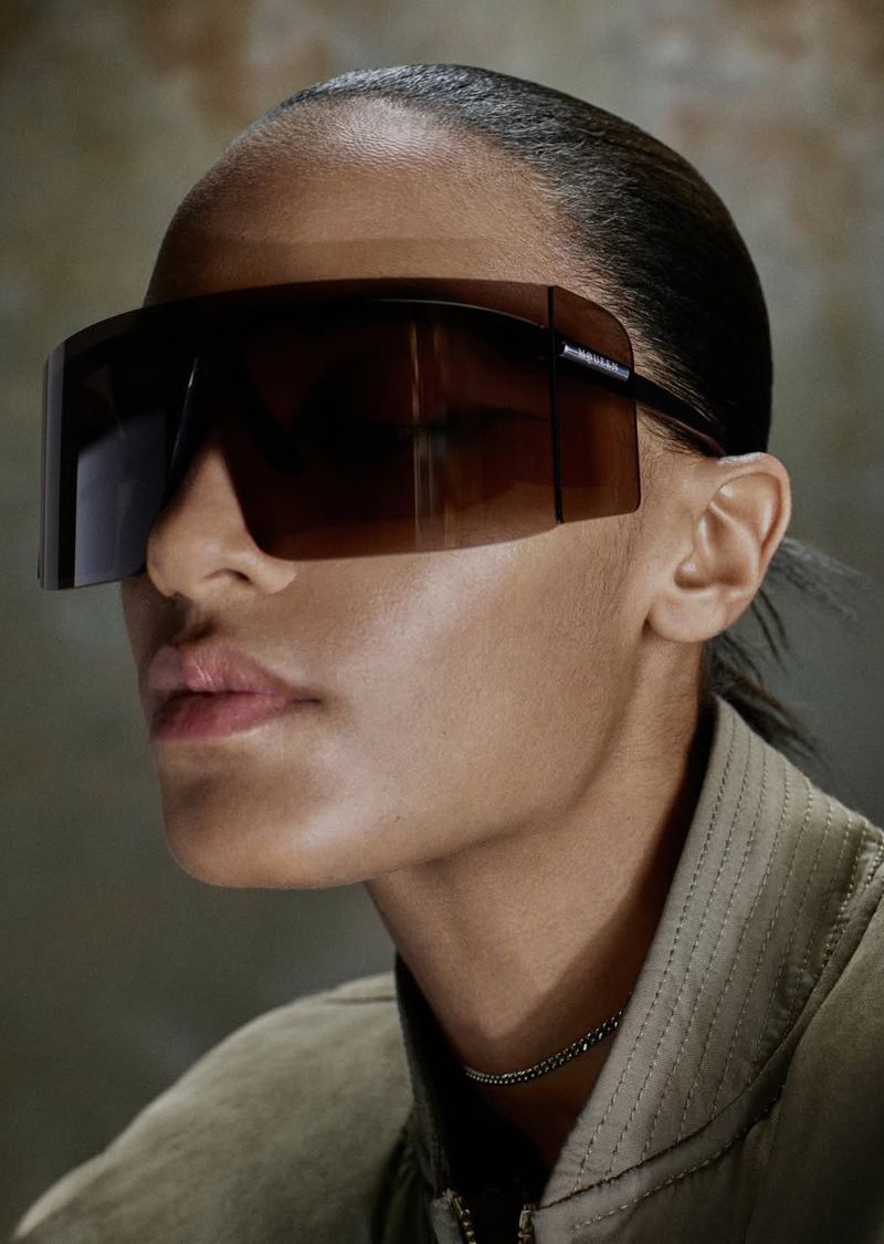Model wearing oversized dark visor sunglasses and khaki jacket for Alexander McQueen S/S 26