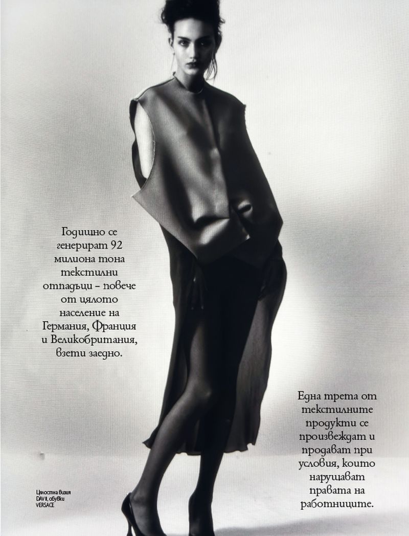 Monochrome fashion shot of a slender female model in a layered black outfit with open-toe heels against a bright background with magazine text.