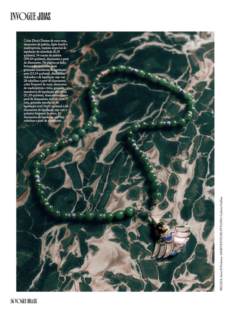 Green bead necklace with a detailed pendant laid on a green marble surface for Vogue Brasil editorial