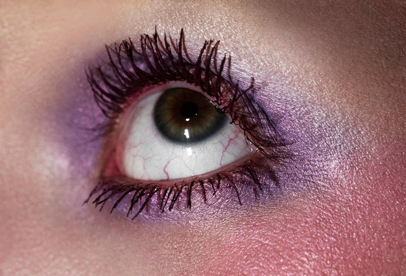Close-up macro shot of a single eye with purple eyeshadow and dark mascara for Beyond Noise