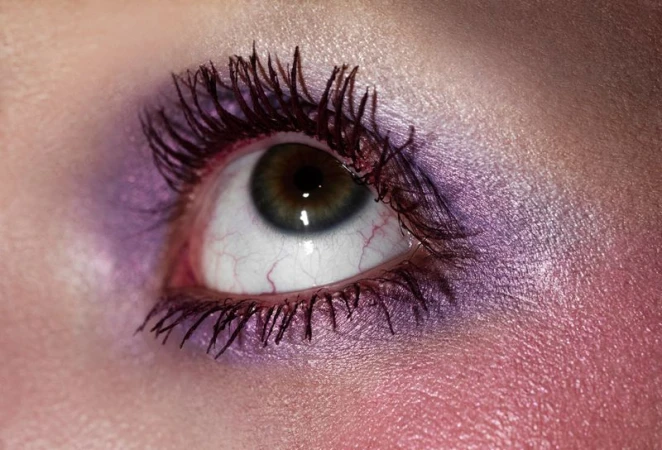 Close-up macro shot of a single eye with purple eyeshadow and dark mascara for Beyond Noise