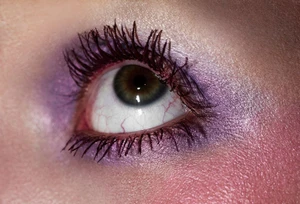 Close-up macro shot of a single eye with purple eyeshadow and dark mascara for Beyond Noise