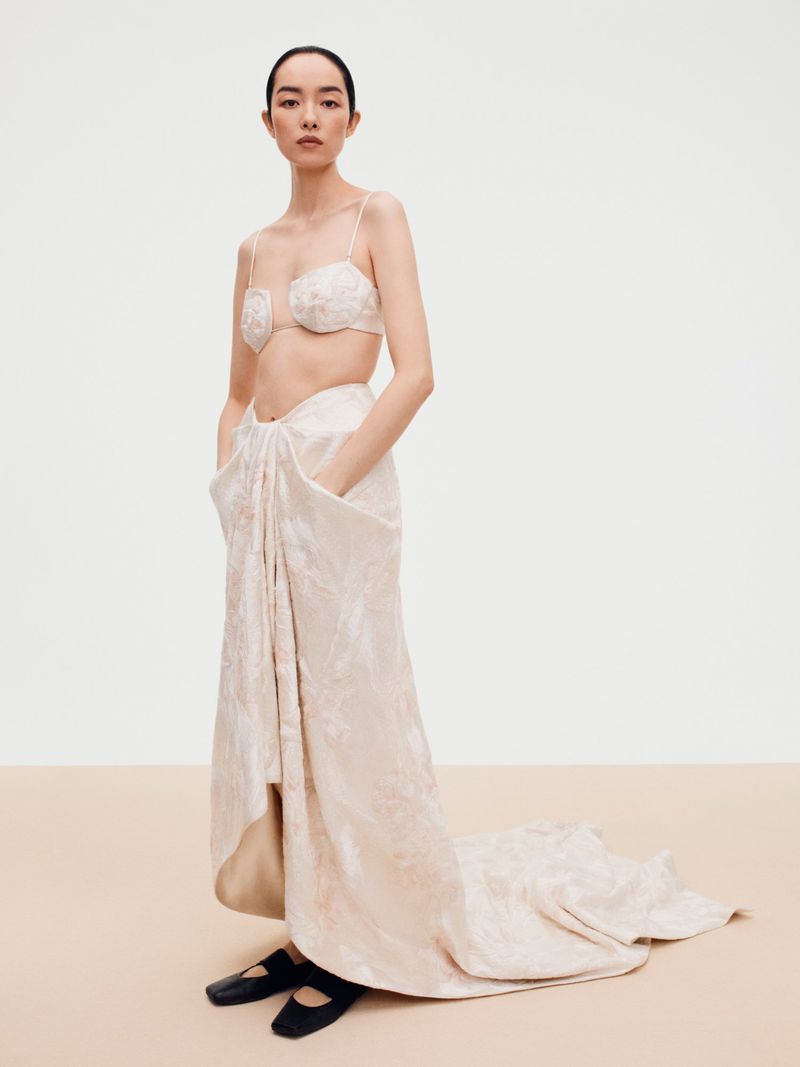 Model FeiFei Sun wearing a cream patterned bra top and long skirt in a studio setting for Beyond Noise