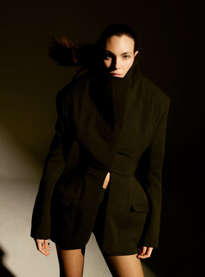 Vittoria Ceretti wearing an oversized black structured jacket in a dark moody portrait by Anthony Seklaoui