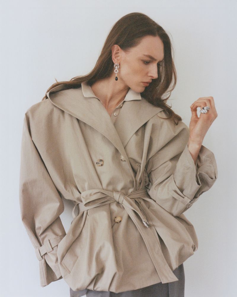 Model Daga Ziober wearing a beige belted trench coat against a white wall for Numéro Istanbul