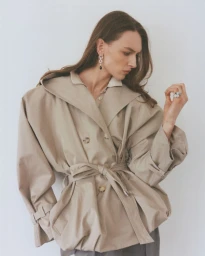Model Daga Ziober wearing a beige belted trench coat against a white wall for Numéro Istanbul