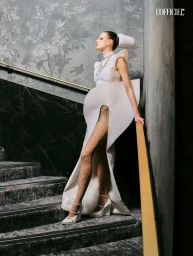 Model in architectural white gown standing on a stairwell for L'Officiel Belgium