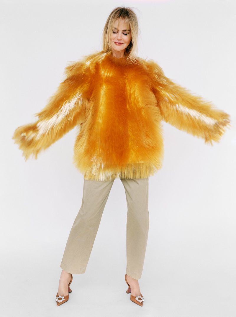 Model in fluffy yellow top wearing neutral trousers against a plain white background for Vogue China editorial