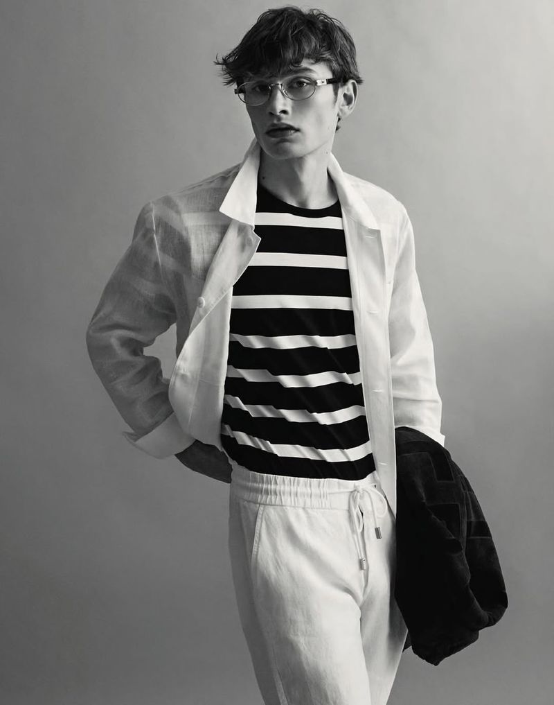 Model Kian Cleator wearing a striped t-shirt and white jacket in a studio portrait for Men's Health Italy