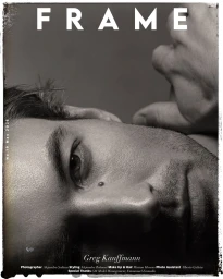 Close-up monochrome portrait of a man's face resting horizontally, featured on a magazine cover with visible distressed border.