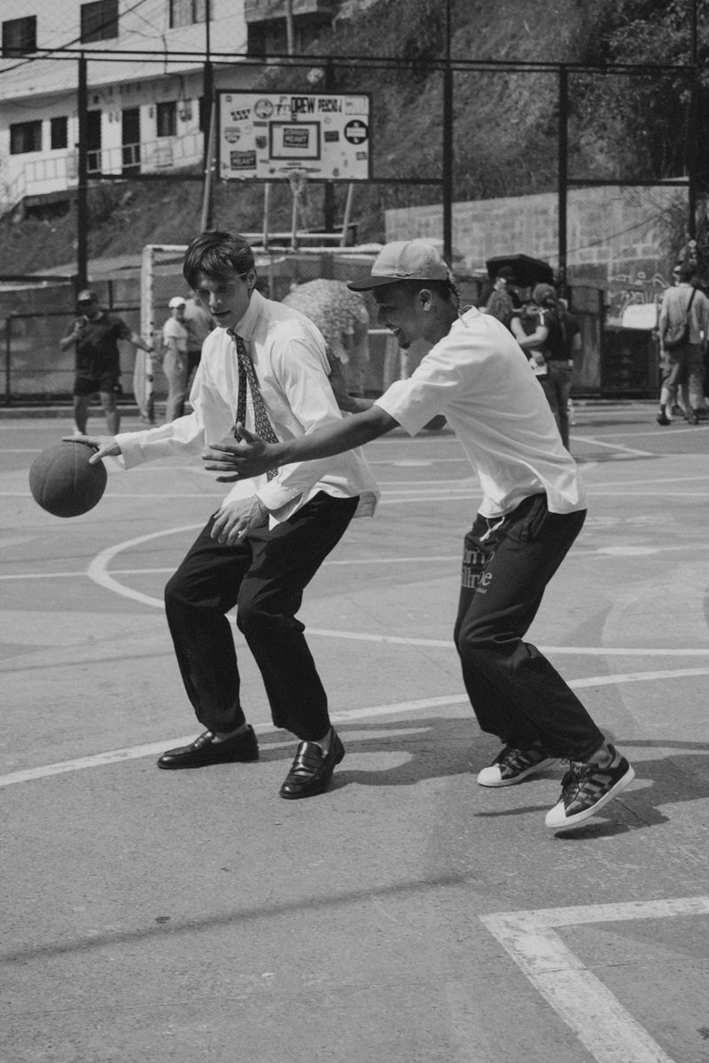 Black and white editorial image of two men playing basketball on an outdoor court for L'Officiel Ukraine