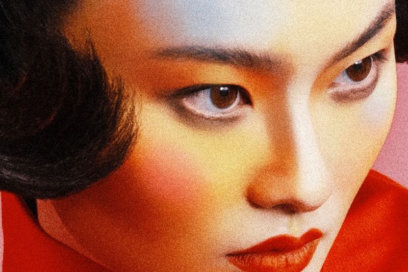Close-up portrait of model He Cong with vibrant makeup and red top for W Magazine China