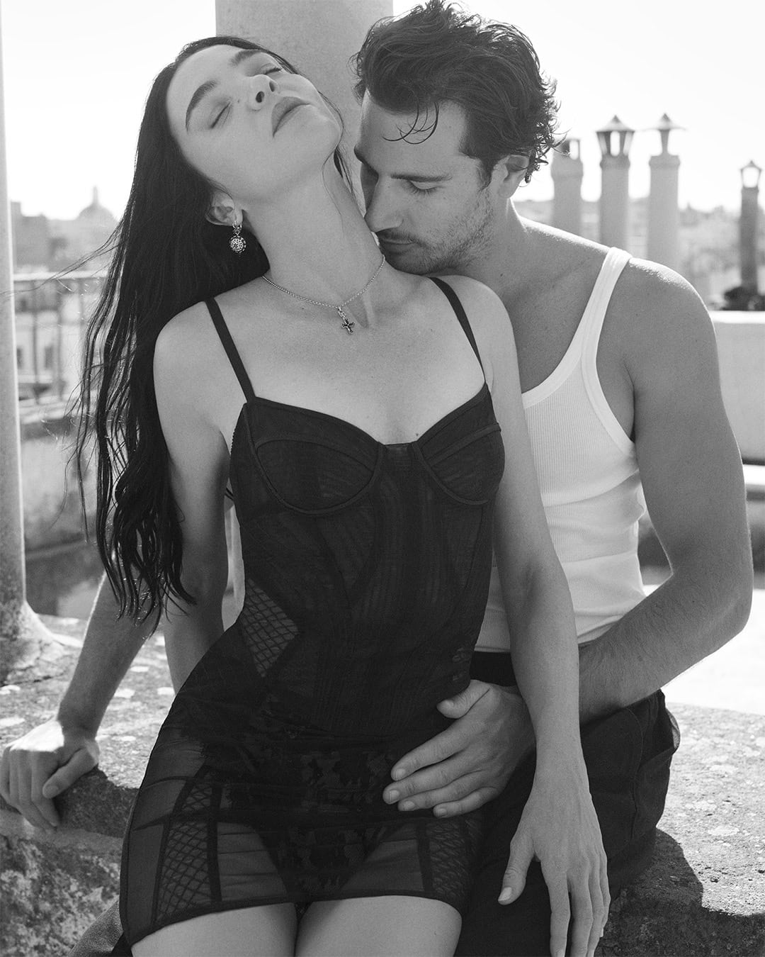 Black and white portrait of a woman in a dark dress and a man in a tank top outdoors in Rome.