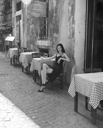 Model Mariacarla Boscono seated outside a restaurant in Rome for Dolce and Gabbana campaign