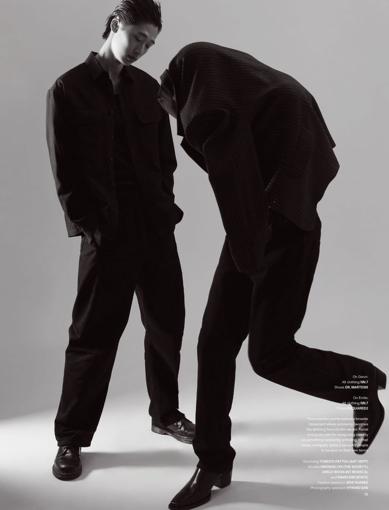 Two male models in dark monochrome outfits posing against a plain light background for V Man Sea editorial.