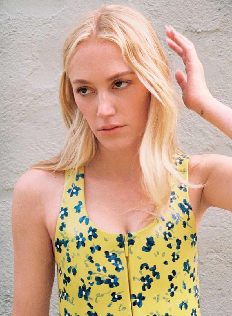 Maika Monroe wearing a yellow floral top against a neutral textured background for HERO USA