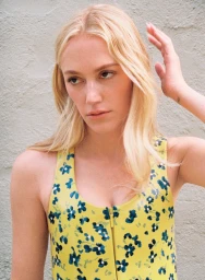 Maika Monroe wearing a yellow floral top against a neutral textured background for HERO USA