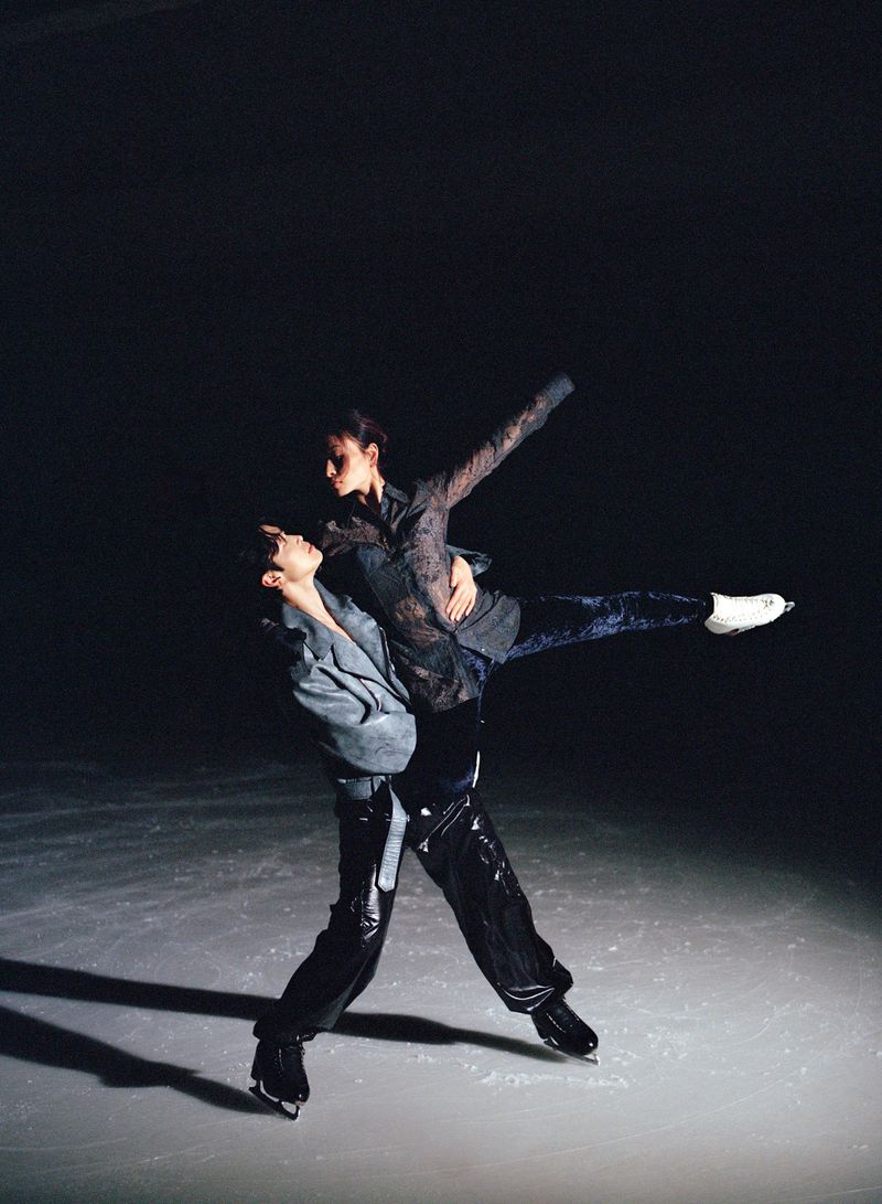 Alex and Maia Shibutani performing an ice skating lift on an ice rink under dramatic low-key lighting for HERO USA.