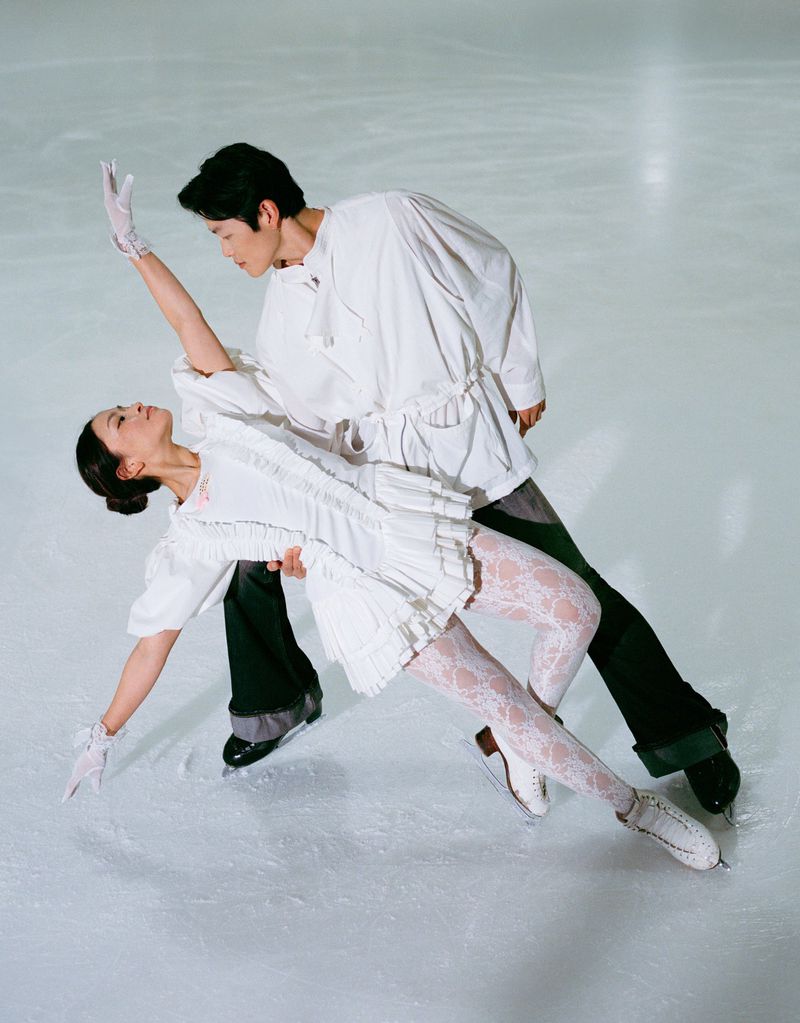 Figure skaters Alex and Maia Shibutani performing on ice in matching white outfits for HERO USA.