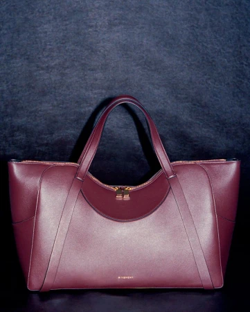 Burgundy leather tote bag centered against a dark textured background for HERO USA project Things That Choose You.
