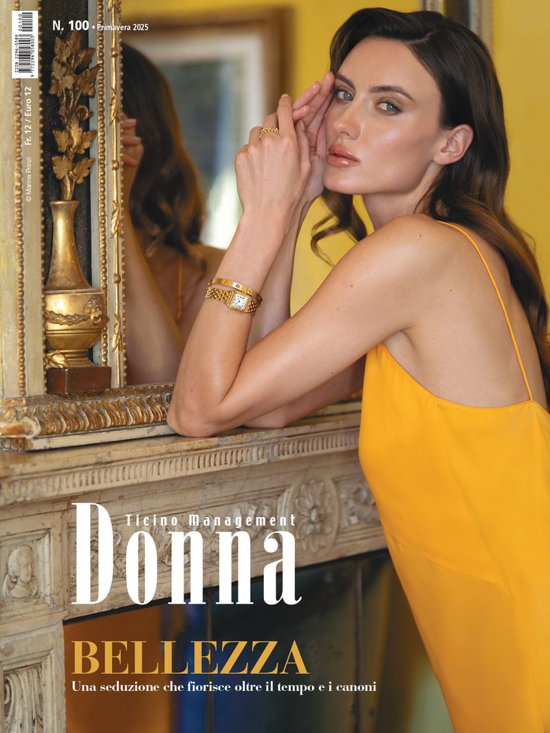 Magazine cover featuring a woman in a yellow dress leaning against a fireplace with mirror reflection, showcasing fashion and beauty elements.