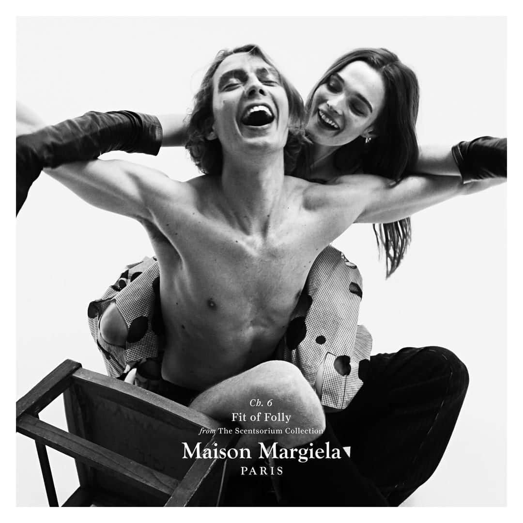 Monochrome campaign image featuring models Leon Dame and Lulu Tenney laughing against a white background for Maison Margiela