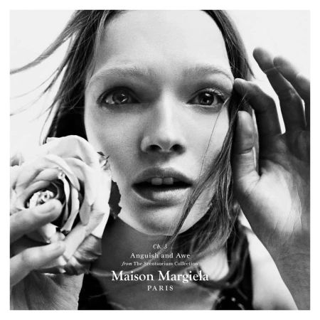 Close-up monochrome portrait of a model holding a rose near her face for Maison Margiela Scentsorium ad campaign