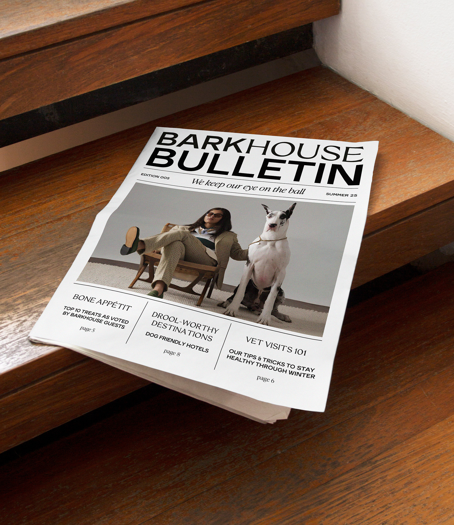 Printed Barkhouse Bulletin magazine publication resting diagonally on a polished wooden staircase